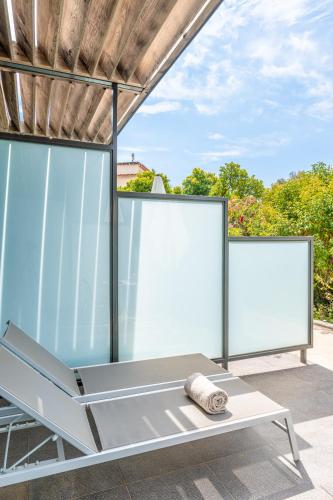 a glass room with a bench in front of two windows at Les Terrasses du Bailli in Rayol-Canadel-sur-Mer