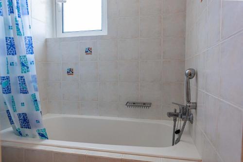 a white bath tub in a bathroom with a window at VillaEvaNafplion in Paralía Iríon