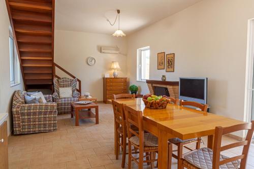 a dining room with a wooden table and chairs at VillaEvaNafplion in Paralía Iríon
