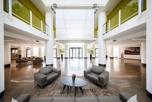 un grand hall avec des canapés et une table dans l'établissement Airporthotel Verona Congress & Relax, à Dossobuono