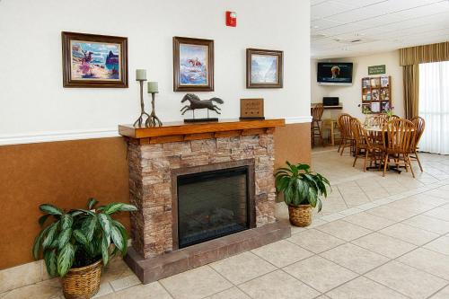 a living room with a fireplace and a dining area at Boothill Inn and Suites in Billings