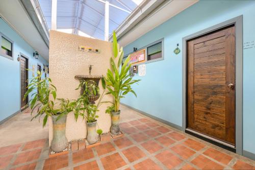 a hallway with potted plants and a wooden door at Pattaya Bed Boutique SHA in Nong Prue