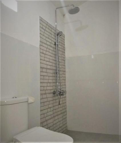 a bathroom with a shower and a toilet in it at Balakosa Gili Meno Bungalow in Gili Meno