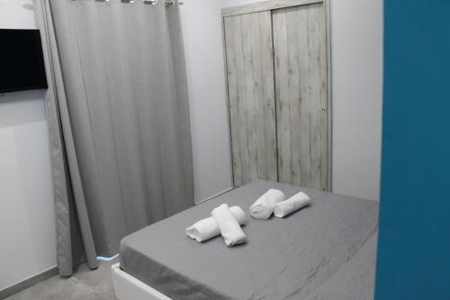 a bedroom with a bed with towels on it at Olive Luxury Rooms in Ýpsos