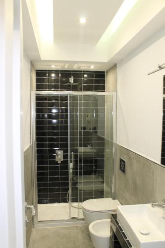 a bathroom with a shower and a toilet and a sink at Olive Luxury Rooms in Ýpsos