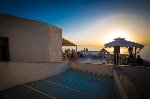 a swimming pool with an umbrella and people on the beach at Villa Solaria in Massa Lubrense