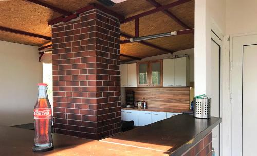 a brick pillar in a kitchen with a bottle of coke at Guest House Villa Rose in Primorsko