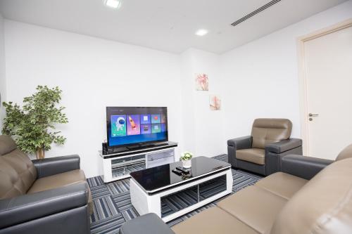 a living room with couches and a flat screen tv at Binjai 8 KLCC by PSM Luxury Suites in Kuala Lumpur