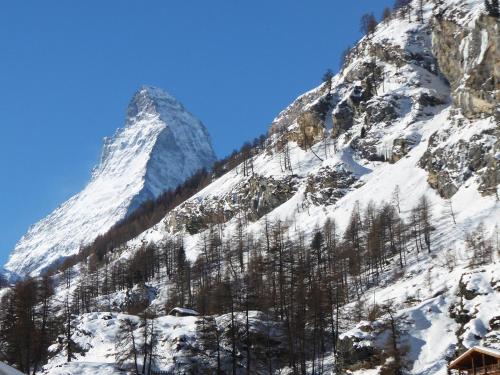 a snow covered mountain with a house in front of it at Haus Viktoria A in Zermatt