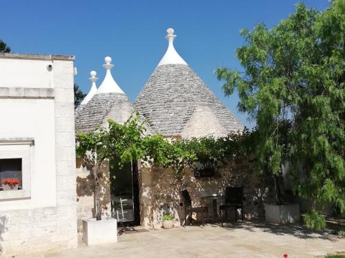 a building with a pyramid roof with a table at Marinelli Guest House in Cisternino