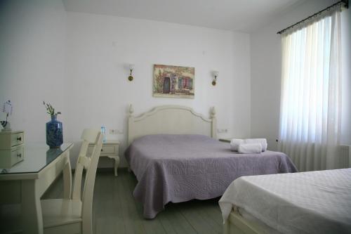 1 dormitorio con 2 camas, escritorio y ventana en Gule Cunda, en Ayvalık