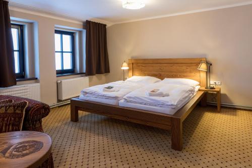 a bedroom with a bed with white sheets and pillows at Luční bouda in Pec pod Sněžkou
