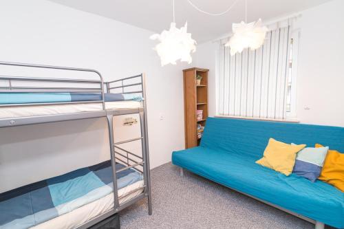 a bedroom with a bunk bed and a blue couch at Apartament Pomorski in Hel