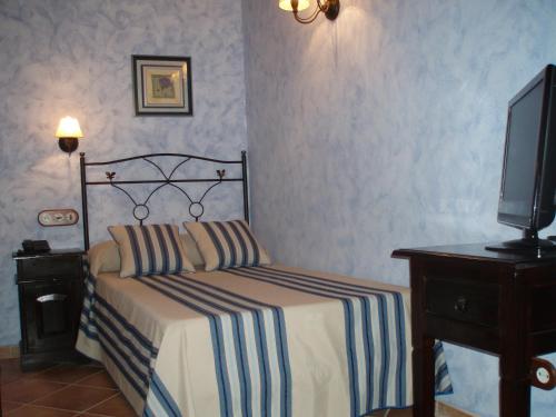 EslidaにあるL' Artesà Turisme Ruralのベッドルーム(ベッド1台、テーブル上のテレビ付)