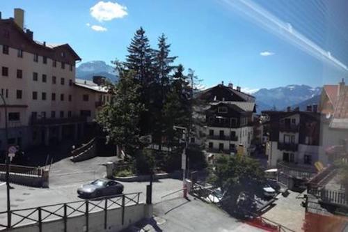 Blick auf eine Stadt mit einem Auto auf einem Parkplatz in der Unterkunft SAUZE 50 MT PISTE CLOTES in Sauze dʼOulx