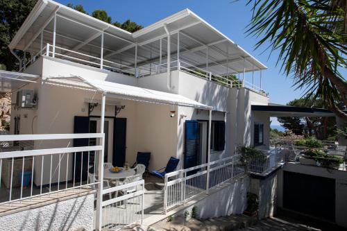 a white house with a balcony with a table at Villa Aurora Mondello Addaura in Mondello