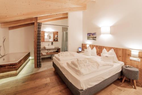 ein Schlafzimmer mit einem großen Bett und einer Badewanne in der Unterkunft B&B Boutique Apartment Oberwiesen in Bruneck