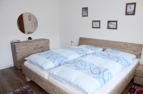 a bedroom with a bed with white and blue pillows at Haus Viktoria A in Zermatt