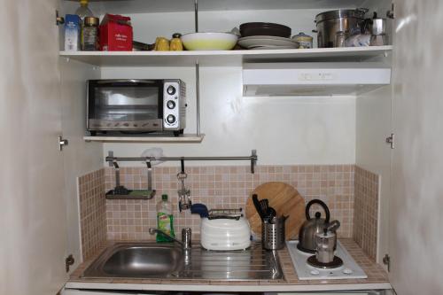 a small kitchen with a sink and a microwave at Home Resuttano in Palermo