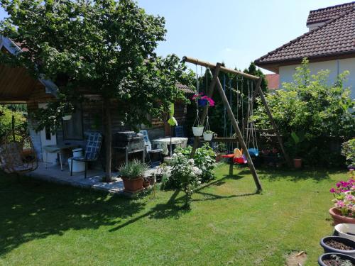 a garden with a swing and some plants at Campingblick-Gästehaus-Ferienwohnungen in Podersdorf am See