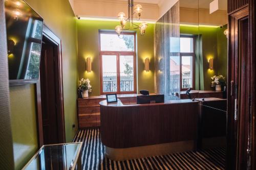 a green room with a reception desk and a window at Vila Siago in Cluj-Napoca