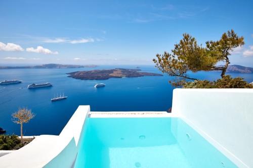 a swimming pool with a view of the ocean at Dreams Luxury Suites in Imerovigli