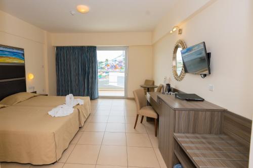 a hotel room with a bed and a desk at Tofinis Hotel in Ayia Napa
