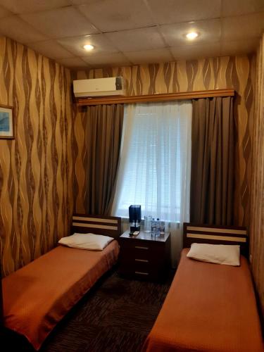 ein Hotelzimmer mit 2 Betten und einem Fenster in der Unterkunft AZPETROL HOTEL GAZAX in Qazax