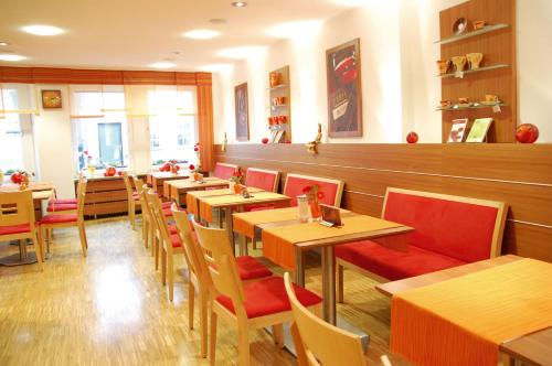 a restaurant with wooden tables and red chairs at Schell Schokoladen in Gundelsheim