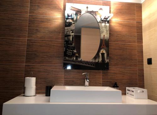 uma casa de banho com um lavatório branco e um espelho. em Contemporary Farmhouse with BBQ in North Evia em Neokhórion