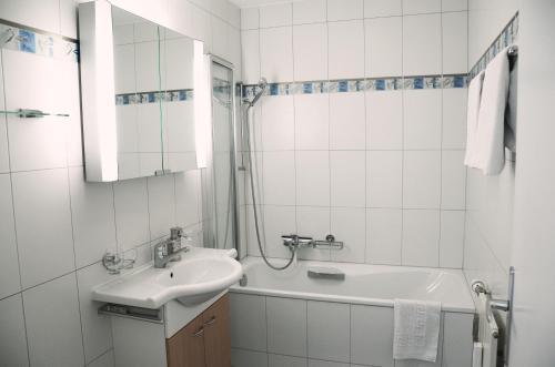 ein weißes Badezimmer mit einem Waschbecken und einer Badewanne in der Unterkunft Haus Viktoria A in Zermatt