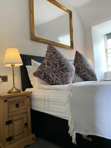 a bedroom with a bed with pillows and a mirror at Royal Mile Balconies by the Castle in Edinburgh