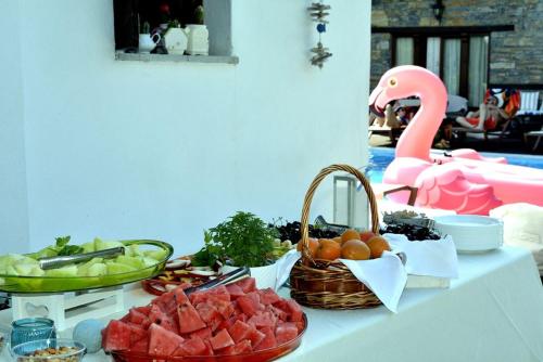 a table with fruits and vegetables and a pink flamingo at Archontiko Naoumidi in Portariá