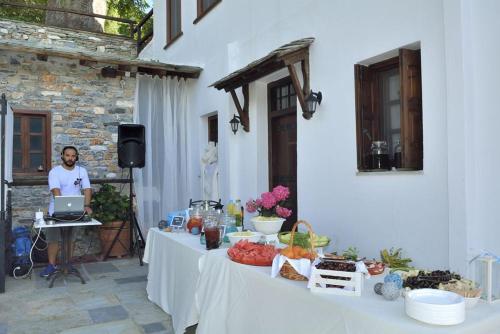 a man is sitting at a table with a laptop at Archontiko Naoumidi in Portariá