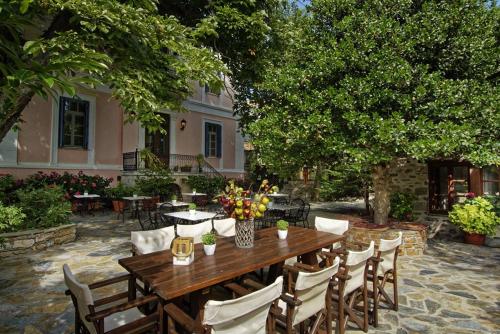 a wooden table and chairs in front of a house at Archontiko Naoumidi in Portariá