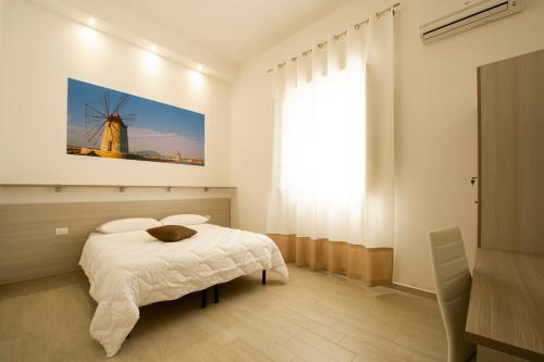 1 dormitorio con 1 cama y un molino de viento en la pared en Sole Mare Sale, en Torre Nubia