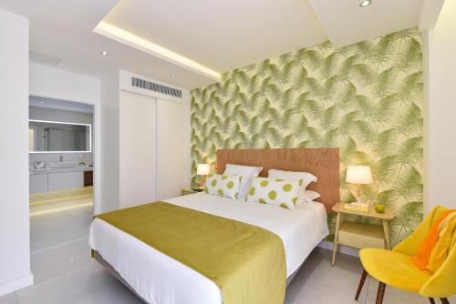 プエルト・デ・モガンにあるMogan Beachfront apartment V&L by VillaGranCanariaのベッドルーム(大型ベッド1台、黄色い椅子付)