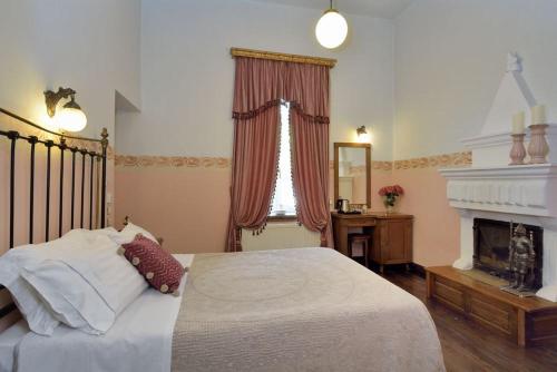 a bedroom with a large bed and a fireplace at Archontiko Naoumidi in Portariá