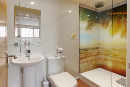 a bathroom with a toilet and a sink and a shower at Silver Street Suites in Whitby