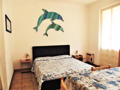 a bedroom with a bed with a dolphin decal on the wall at Sun's Homes "Red" in Portofino