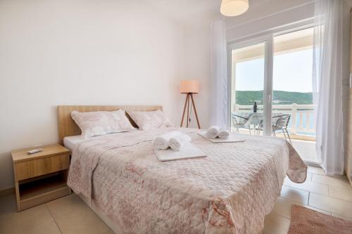 a bedroom with a large bed with towels on it at Apartments Lavanda in Neum
