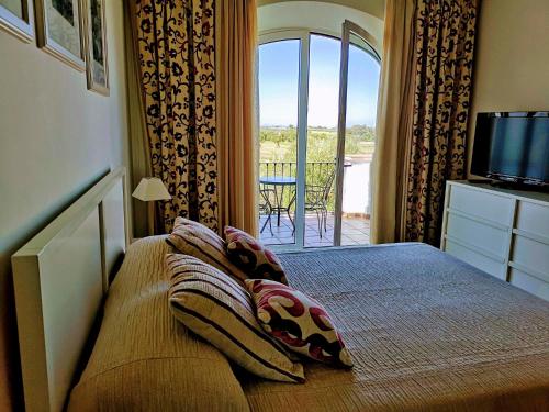 um quarto com uma cama e vista para uma varanda em FAIRWAY GARDENS em Arcos de la Frontera