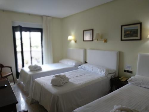 a hotel room with two beds with towels on them at Balneario de Ledesma in Vega de Tirados