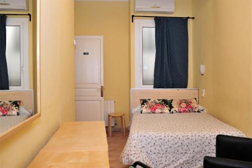 a small bedroom with a bed and a mirror at Hostal Bejar in Barcelona