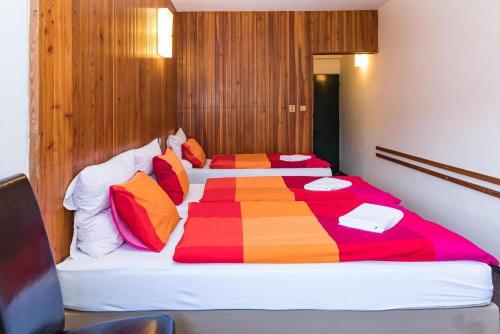 a bedroom with two beds with a colorful comforter at Hotel Labská bouda in Horni Misecky
