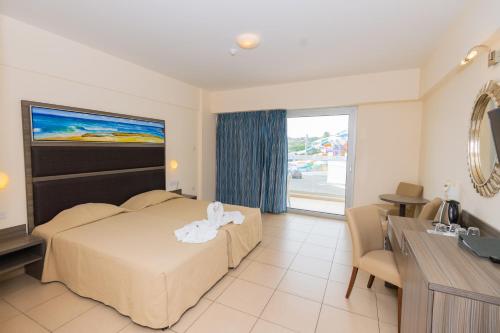 a hotel room with a bed and a table and a desk at Tofinis Hotel in Ayia Napa