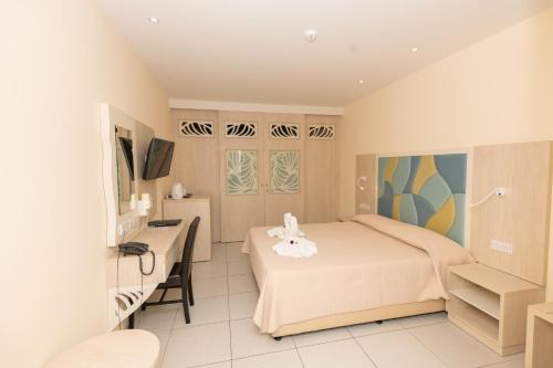a small bedroom with a bed and a desk at Tofinis Hotel in Ayia Napa