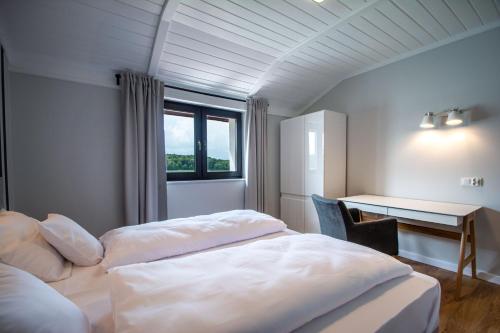 a bedroom with two beds and a desk and a window at Tawerna Kaszubska in Ostrzyce