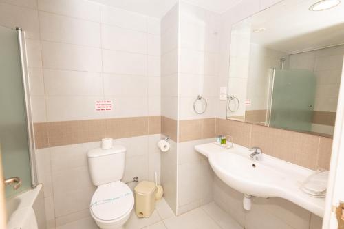 a bathroom with a toilet and a sink at Tofinis Hotel in Ayia Napa