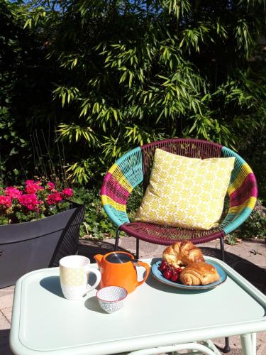 una mesa con una bandeja de cruasanes y tazas y una almohada en La Bohème en Tournon-sur-Rhône